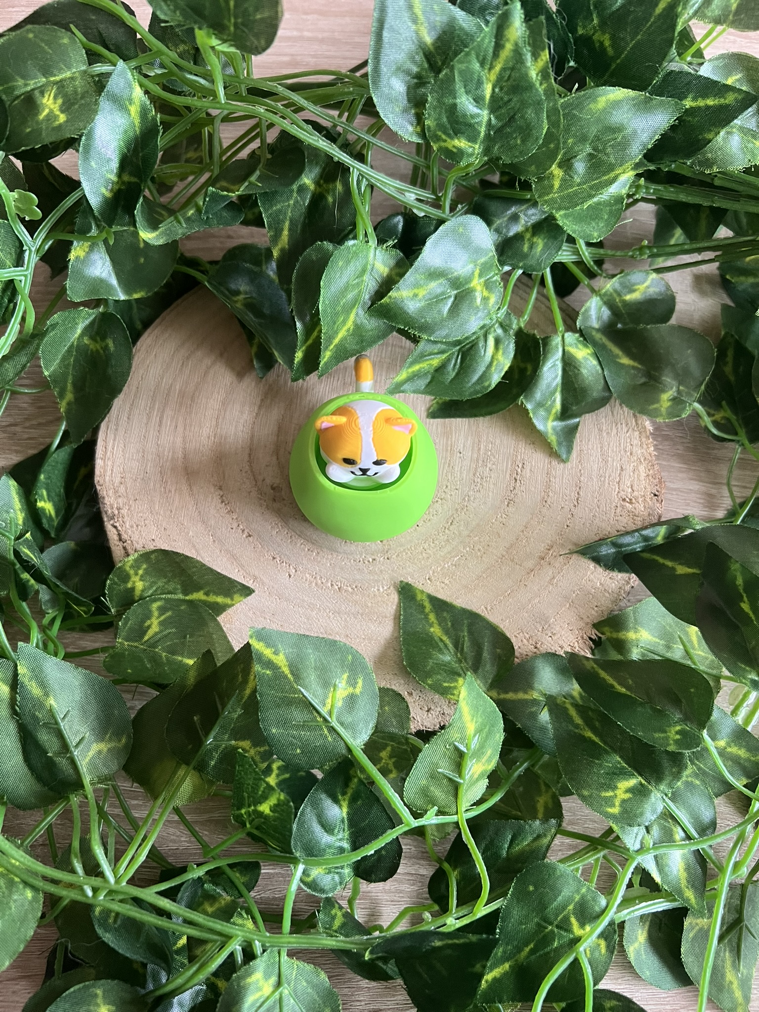 Llavero tipo clicker con impresión 3D del gato aceituno (Benjamín) que es un gato naranja y blanco metido en una aceituna verde