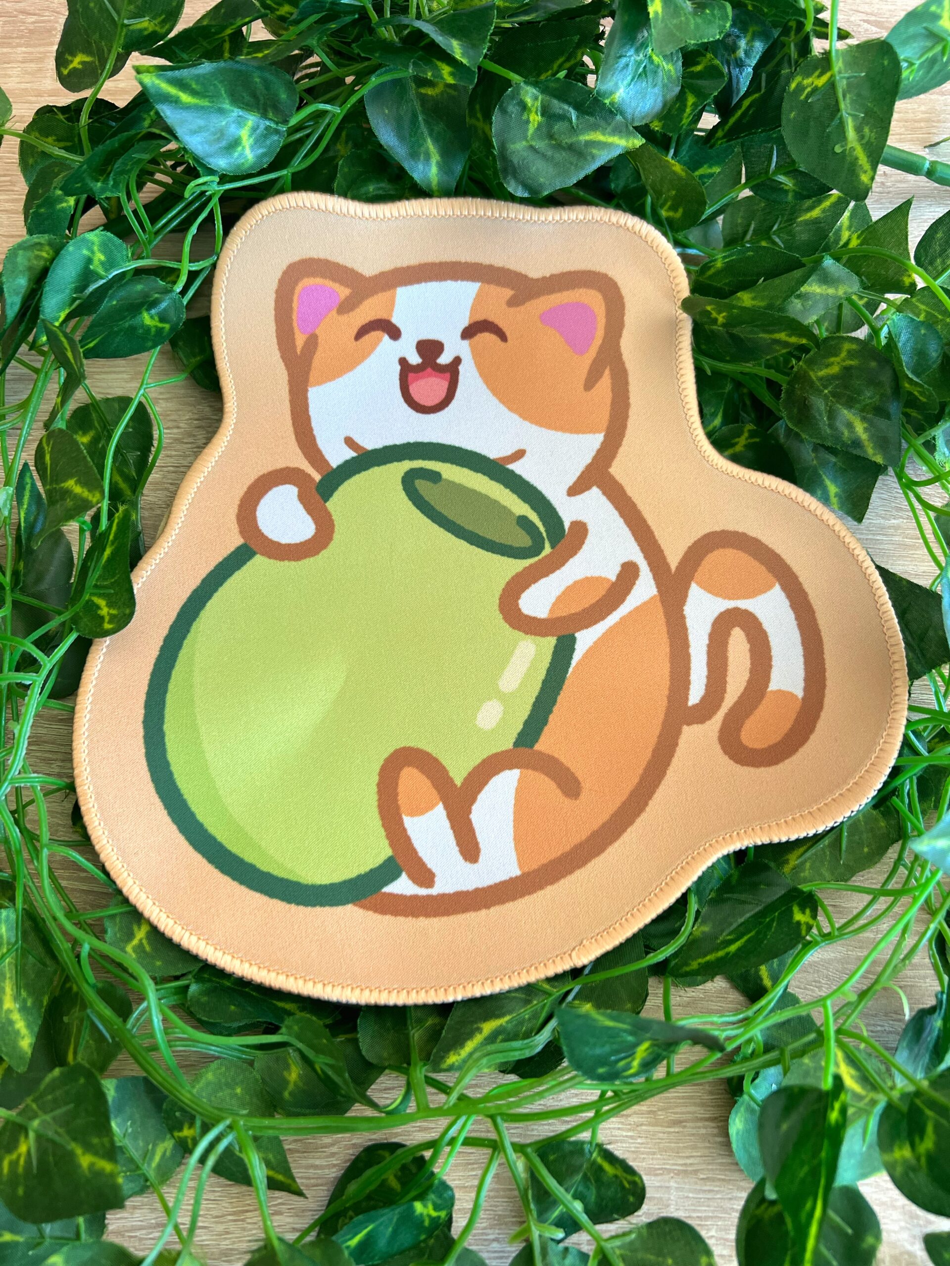Mouse pad del gato aceituno (Benjamín) abrazando una aceituna verde. El gato está contento y es blanco y naranja